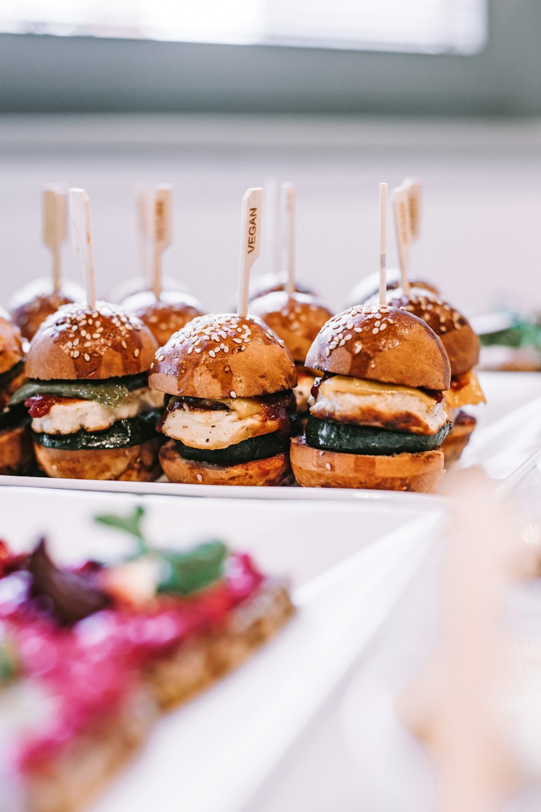 a row of mini sandwiches sitting on top of a white plate